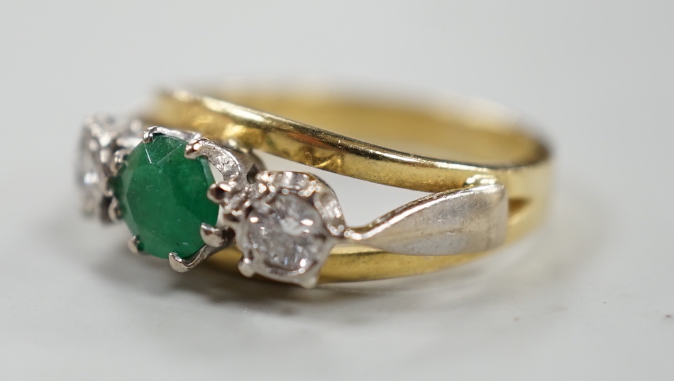 A modern yellow metal, emerald and diamond set three stone ring, size G, gross weight 3.8 grams.